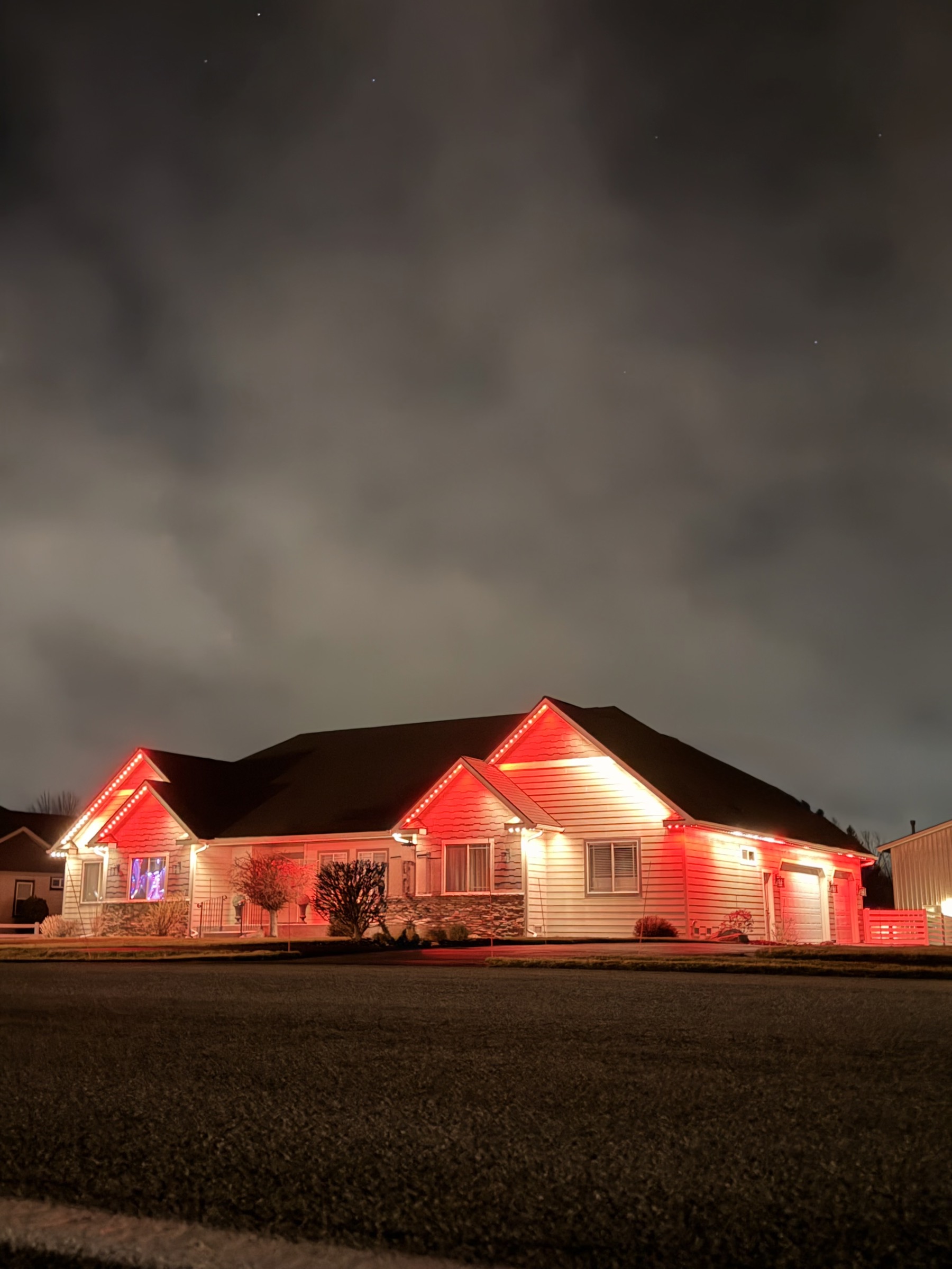A home's roofline lit in red trim lighting at night