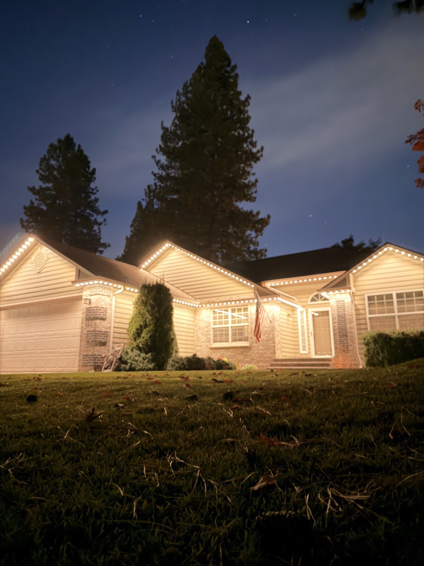A home's front entrance lit with warm white trim lighting at dusk