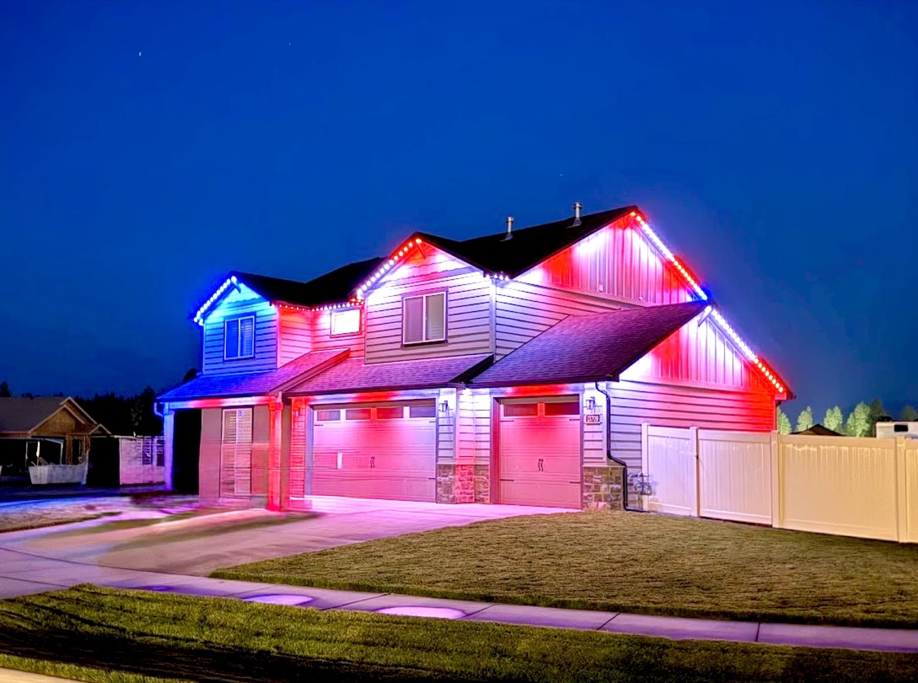 A home lit in red, white, and blue trim lighting at night