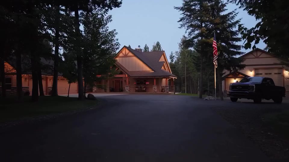 A lodge-style home at dusk with warm LED trim lighting along its roofline