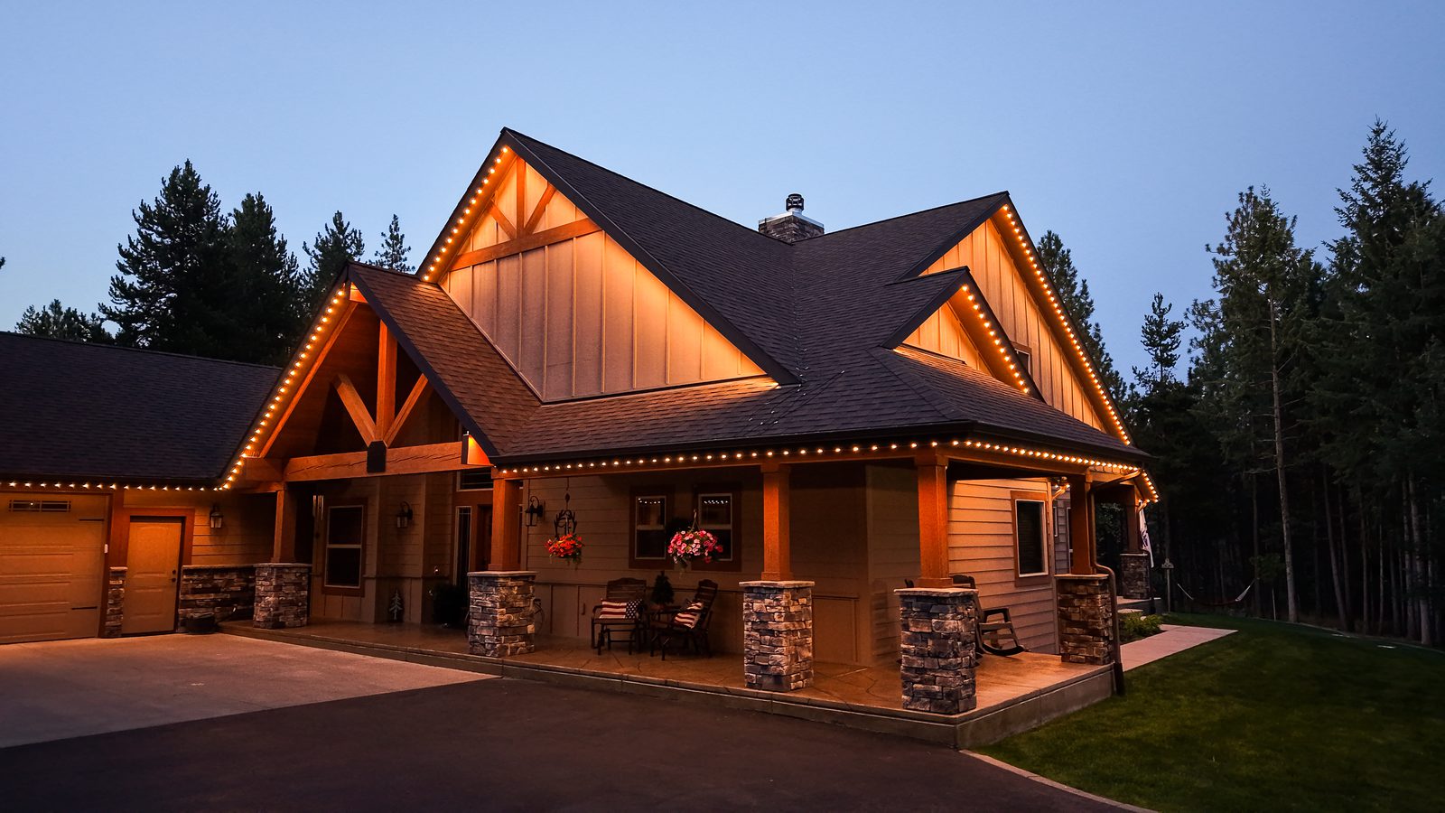 A home's roofline lit with warm Luxe permanent lighting after dark